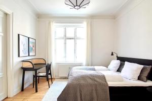 Un dormitorio con una cama y un escritorio y una ventana. en Huge modern & central 2BR loft, en Copenhague