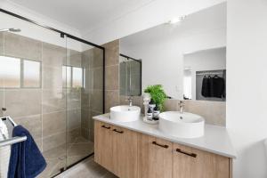 a bathroom with two sinks and a shower at Noble Casa Brand New Estate Sleeps 8 Burpengary East in Morayfield