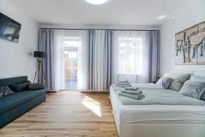 salon z białą kanapą i niebieską kanapą w obiekcie AusZeit Steiraland 2 mit privaten Terrasse und Garten und Parkplatz w mieście Nennersdorf