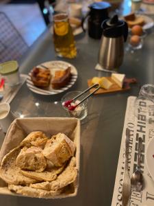 una mesa cubierta con una caja de pan y platos de comida en Le Haut Pont de la Baie, en Mont-Dol
