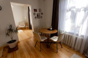 a small table and chairs in a room with a window at Parka ielas apartamenti in Alūksne +8 photos