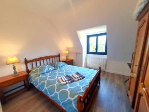 a bedroom with a blue bed with two pillows on it at Le pré Colas- la maison néo bretonne in Pordic