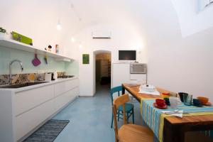 a kitchen and dining room with a table and a sink at The Amalfi Blue Door in Amalfi