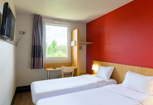 a hotel room with two beds and a window at B&B HOTEL Marne-la-Vallée Bussy-Saint-Georges in Bussy-Saint-Georges +36 photos