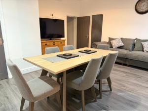 a dining room table with chairs and a couch at Elegance meets Comfort Free Parking Wifi Netflix and Ensuite Bathrooms in Birmingham
