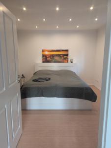 a bedroom with a bed with a painting on the wall at Ferienwohnung Brückenblick 85112 in Ostrhauderfehn