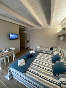 een slaapkamer met 2 bedden en een tafel en een televisie bij Paradise Rooms Apartment in Porto Cesareo +22 foto's