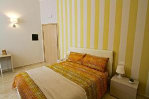 a bedroom with a bed and a striped wall at La Passeggiata di Girgenti in Agrigento