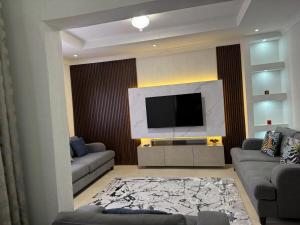 un soggiorno con una TV a schermo piatto su una parete di Kachimam Apartment a Lusaka