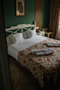 a bedroom with a large bed with a red and white blanket at Nuevo Hotel Parque Cabaneros in Horcajo de los Montes