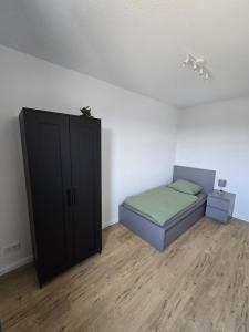 a bedroom with a bed and a black cabinet at Apartment Sonnenblick in Bohmte