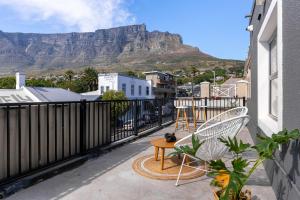 a balcony with a table and chairs and a mountain at CURIOCITY Kloof Street in Cape Town