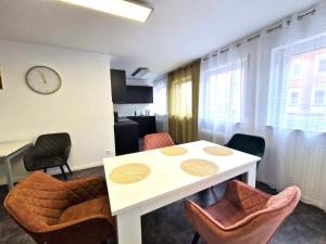 a room with a table and chairs and a clock at Zentrale Wohnung in Göppingen, Bahnhof fußläufig erreichbar in Göppingen