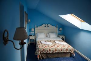a blue bedroom with a bed with two towels on it at Nuevo Hotel Parque Cabaneros in Horcajo de los Montes