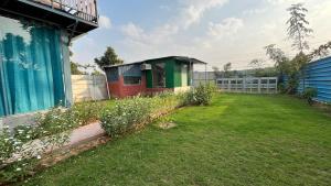 a garden with a small building on the side of a house at Brasa farm in Gurgaon