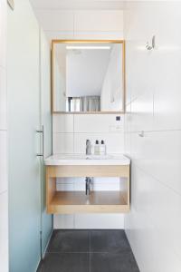 a bathroom with a sink and a mirror at Duinhotel Tien Torens in Zoutelande