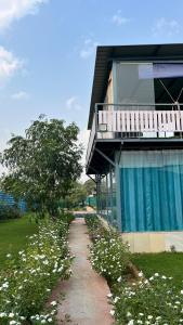 a pathway leading to a house with a balcony at Brasa farm in Gurgaon