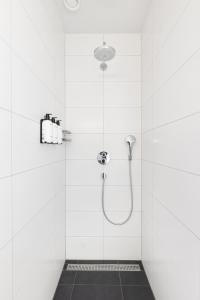 a bathroom with a shower with white tiles at Duinhotel Tien Torens in Zoutelande