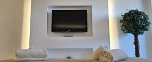 a living room with a tv on a wall at Peixe and Barco Studio's in Vilamoura