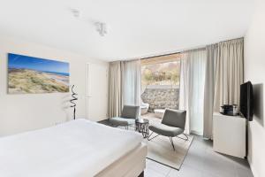 a hotel room with a bed and a tv at Duinhotel Tien Torens in Zoutelande