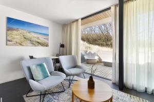 a living room with two chairs and a table at Duinhotel Tien Torens in Zoutelande