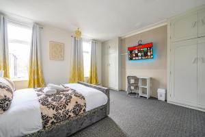 Un dormitorio con una cama y un televisor en la pared. en -RC15CFA- For Relaxed and Cosy stay with Free Parking, en Leeds