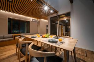 a dining room with a wooden table and chairs at 華ならまち in Nara