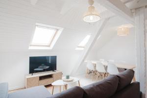 a living room with a couch and a tv and a table at Duplex proche centre ville in Strasbourg
