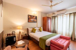 una stanza d'albergo con un letto e una sedia di Chocolat house a Bangalore