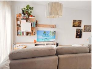 a living room with a couch and a flat screen tv at Casa MarTeu in Pêra