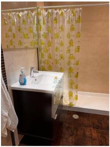 a bathroom with a sink and a shower curtain at Casa MarTeu in Pêra +8 photos