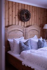 a bed with a wooden head board with pillows at Hoel Gård - Herregården ved Mjøsa in Nes i Ådal