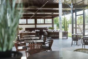 an empty restaurant with tables and chairs and windows at Agriturismo Zapparè Farm Hotel in Trevignano