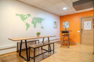 a room with a table and a world map on the wall at HolidaysBCN Rooms in Barcelona