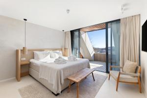 a bedroom with a large bed and a balcony at Duinhotel Tien Torens in Zoutelande