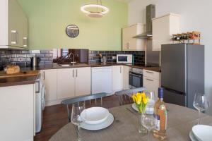 Una cocina con una mesa con sillas y un refrigerador. en The Seagull Apartment, en Cowes