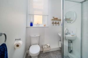 Un baño blanco con inodoro y lavabo. en The Seagull Apartment, en Cowes 4 fotos más