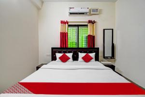 a bedroom with a large white bed with red pillows at Hotel O SR PALACE in Bārang