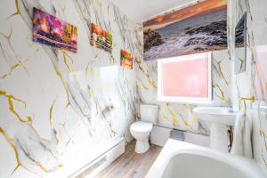 a bathroom with a white toilet and a sink at -RD15CFA- For Relaxed and Cosy stay with Free Parking in Leeds +14 photos