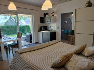 a bedroom with a bed and a table and a kitchen at Le Clos des Pommiers in Tracy-sur-Mer