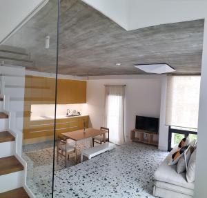 a living room with a glass staircase and a table at Apartamento Centola julio y agost min 7N in Cangas de Morrazo