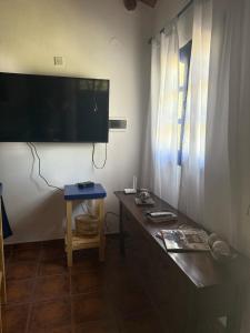 a living room with a table and a flat screen tv at Cabaña Chañar in Capilla del Monte