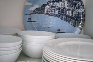 a group of white bowls and plates on a shelf at Westhill, Cowes Town House in Cowes