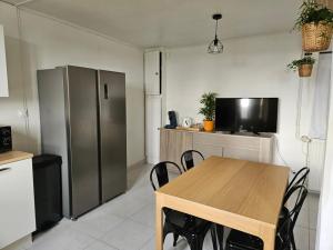 a kitchen with a wooden table and a refrigerator at Petite maison 2 chambres Guéret in Guéret