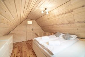 a bedroom with a bed in a wooden room at Sosnowa Chatka in Jelenia Góra