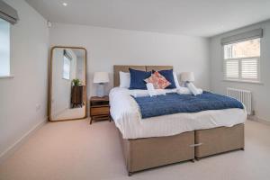 Un dormitorio con una cama grande y un espejo. en Coach House, Cowes, en West Cowes