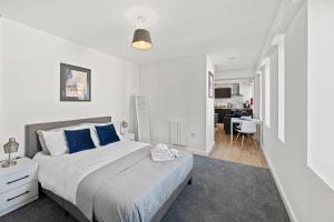 a bedroom with a large bed with blue pillows at Alexandra House by Guestz in Stockport