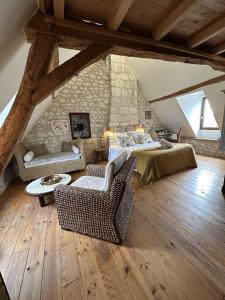a attic room with a bed and a couch and chairs at Aquarelle in Sainte-Maure-de-Touraine