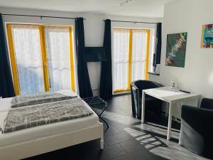Un dormitorio con una cama, un escritorio y ventanas. en New Green Apartments, en Berlín