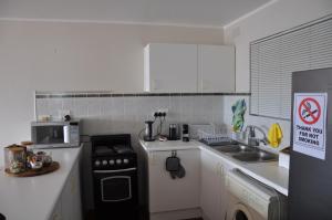 a small kitchen with a stove and a microwave at Suite at Bay in Mossel Bay +16 photos